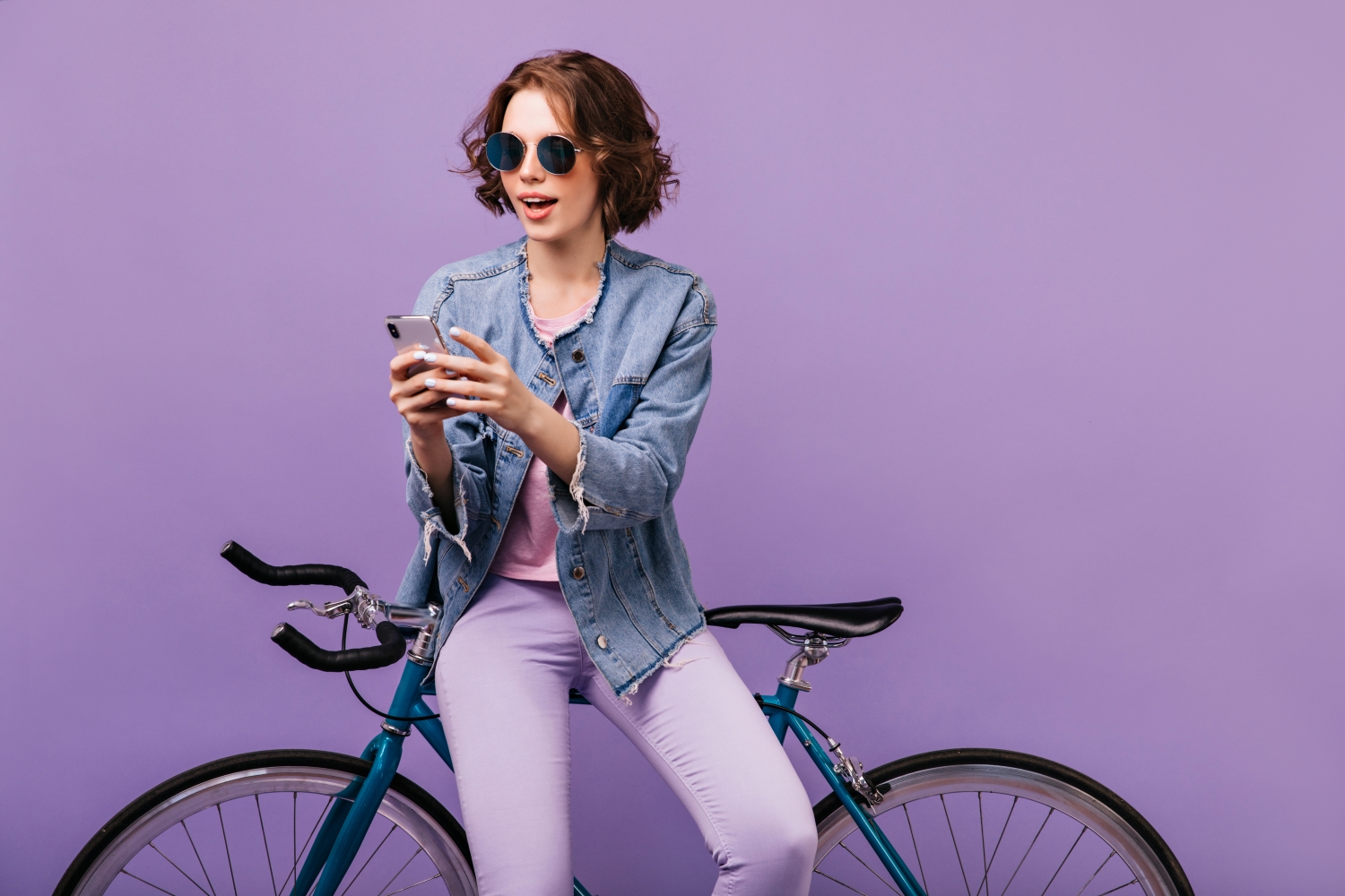 Persona con bici sobre fondo morado